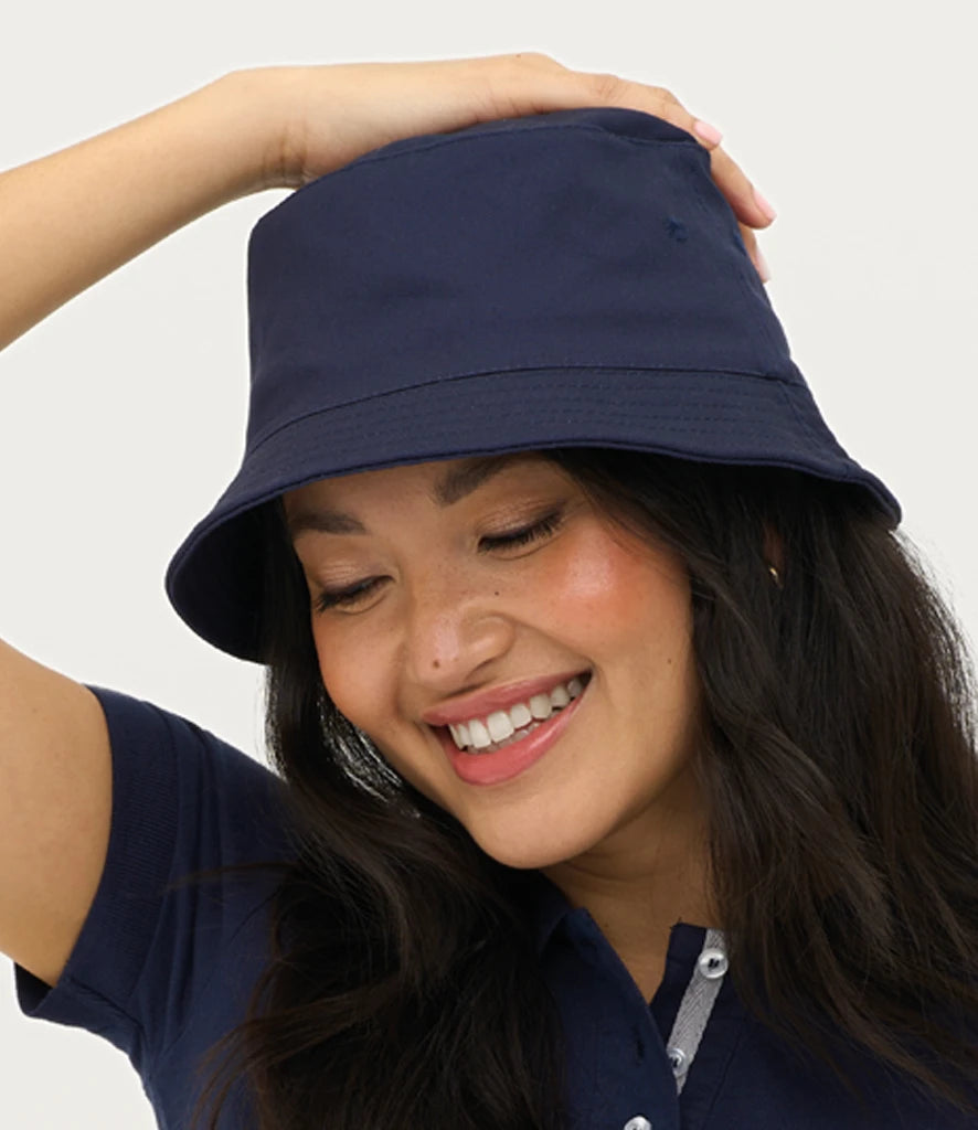 Woman wearing a sols's unisex twill bucket hat in navy blue against a plain backgroung