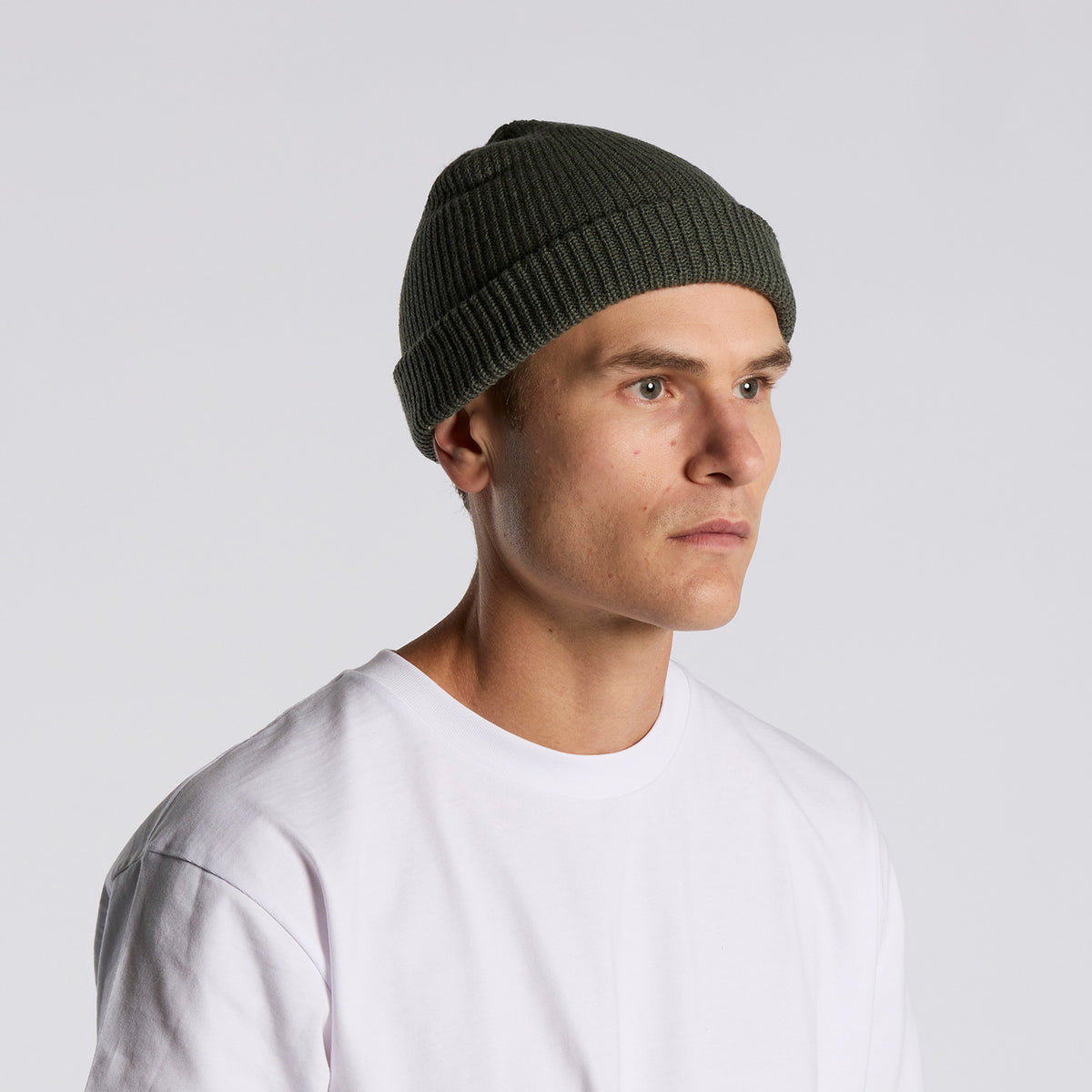 side image of model wearing as colour cable beanie in colour cypress