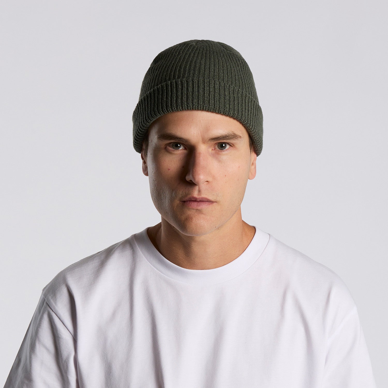 front image of model wearing as colour cable beanie in colour cypress