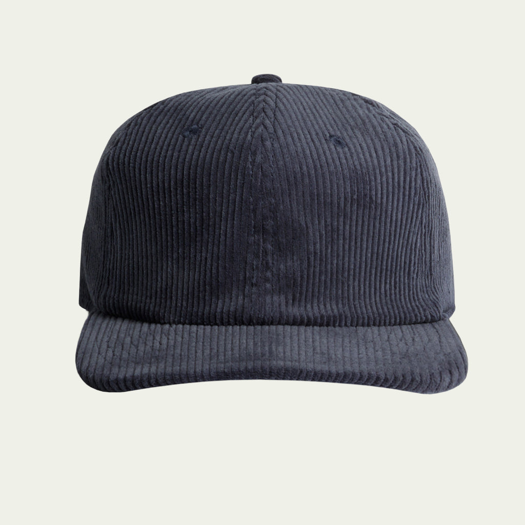 Navy blue corduroy cap on a light beige background