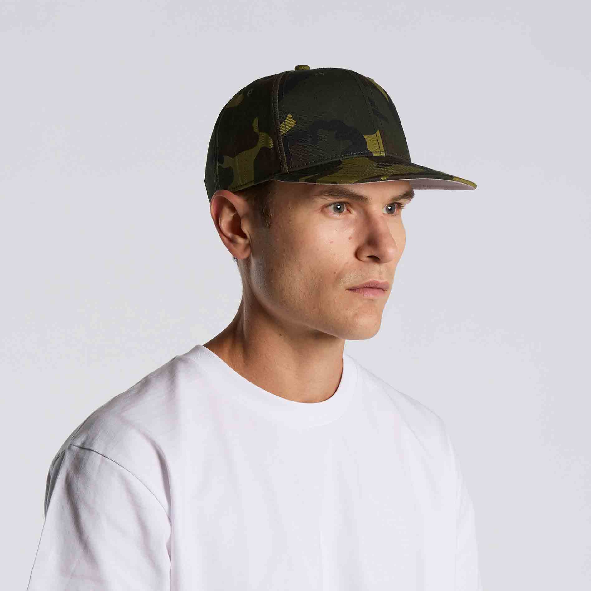 Man wearing as colour stock camo cap against a white background viewed from the side
