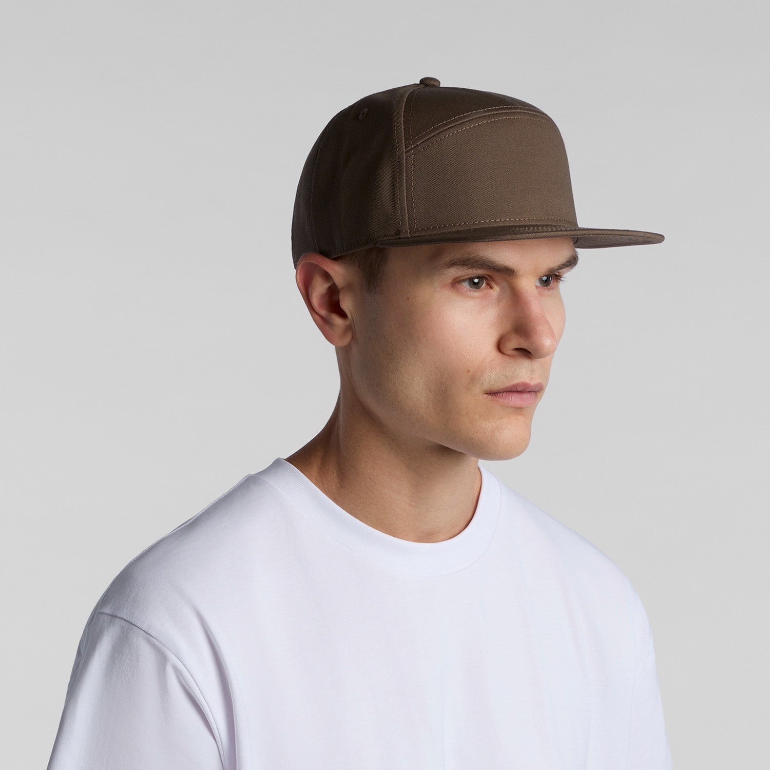 side image of model wearing as colour stock 7 panel cap in colour walnut