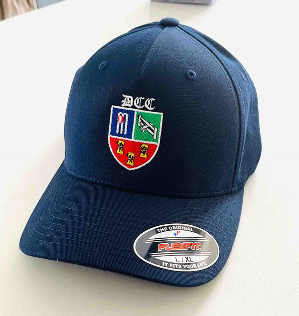 Blue cap with an embroidered cricket club logo on a plain white surface