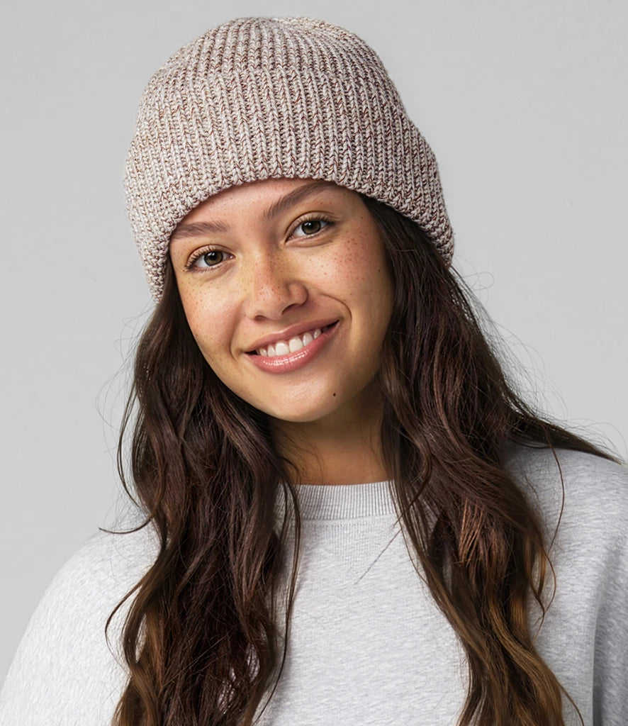 female model wearing beechfield campfire beanie in colour oatmeal speck shot on a grey background