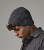 male model wearing Beechfield Organic Cotton Waffle Beanie in colour graphite grey photographed from the side on a grey background