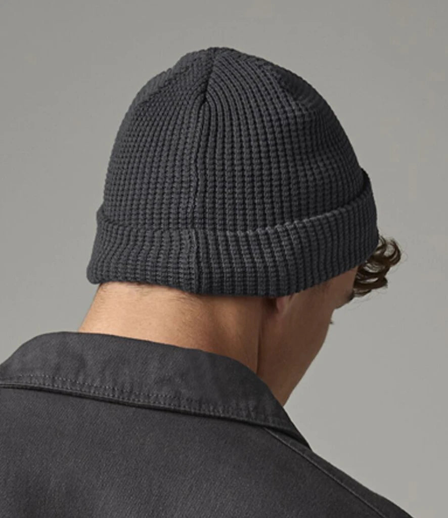 male model wearing Beechfield Organic Cotton Waffle Beanie in colour graphite grey photographed from behind on a grey background