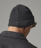 male model wearing Beechfield Organic Cotton Waffle Beanie in colour graphite grey photographed from behind on a grey background