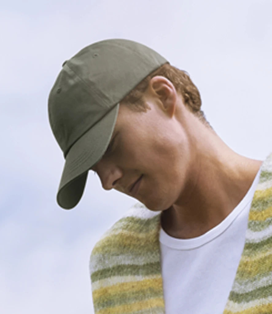 image of male model wearing Beechfield Low Profile 6 Panel Dad Cap in olive viewed from the side on a white background
