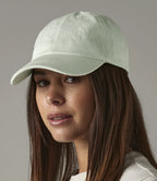 image of female model wearing Beechfield Low Profile 6 Panel Dad Cap in pastel mint viewed from the side on a grey background
