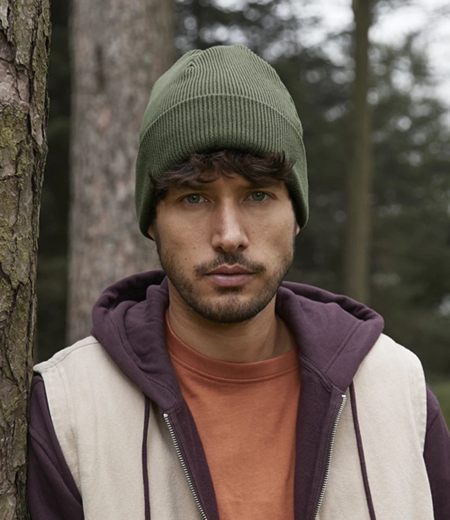 Model image of Beechfield Organic Cotton Original Heavyweight Cuffed Beanie in the colour olive green worn by male model in a forest