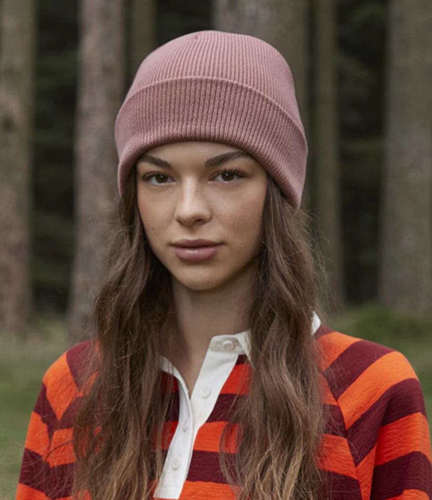Model image of Beechfield Organic Cotton Original Heavyweight Cuffed Beanie in the colour rose worn by female model in a forest