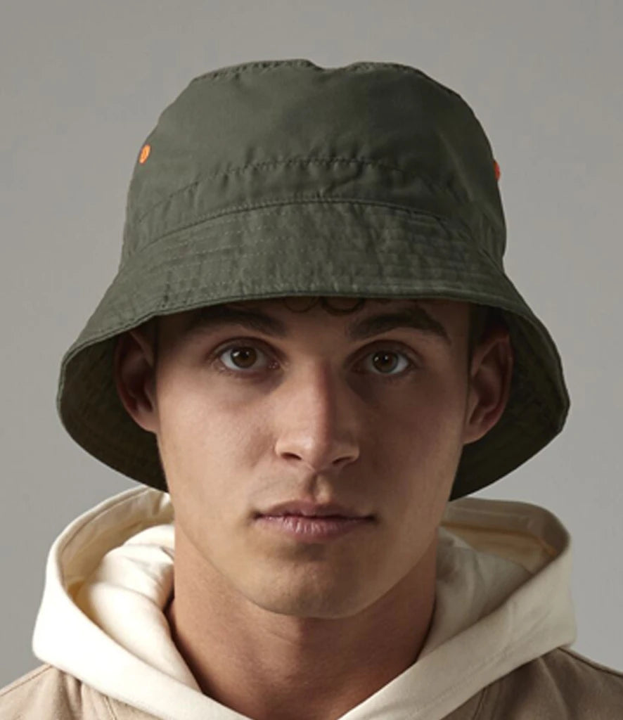 Person wearing a green bucket hat against a gray background