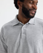 Model wearing uneek uc102 heavyweight polo-shirt in heather grey colour