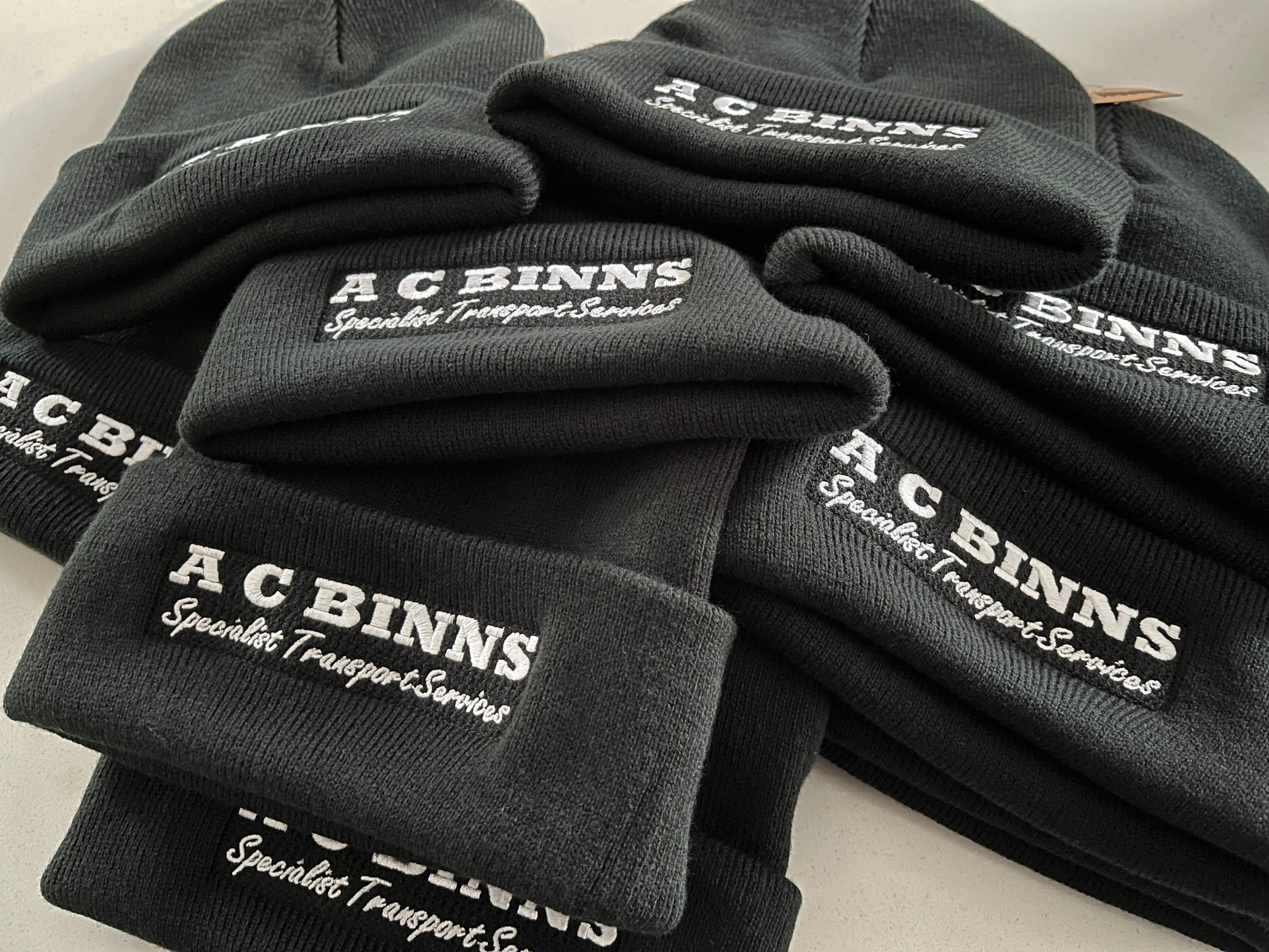 black cuffed beanie with AC Binns Logo embroidered in white thread