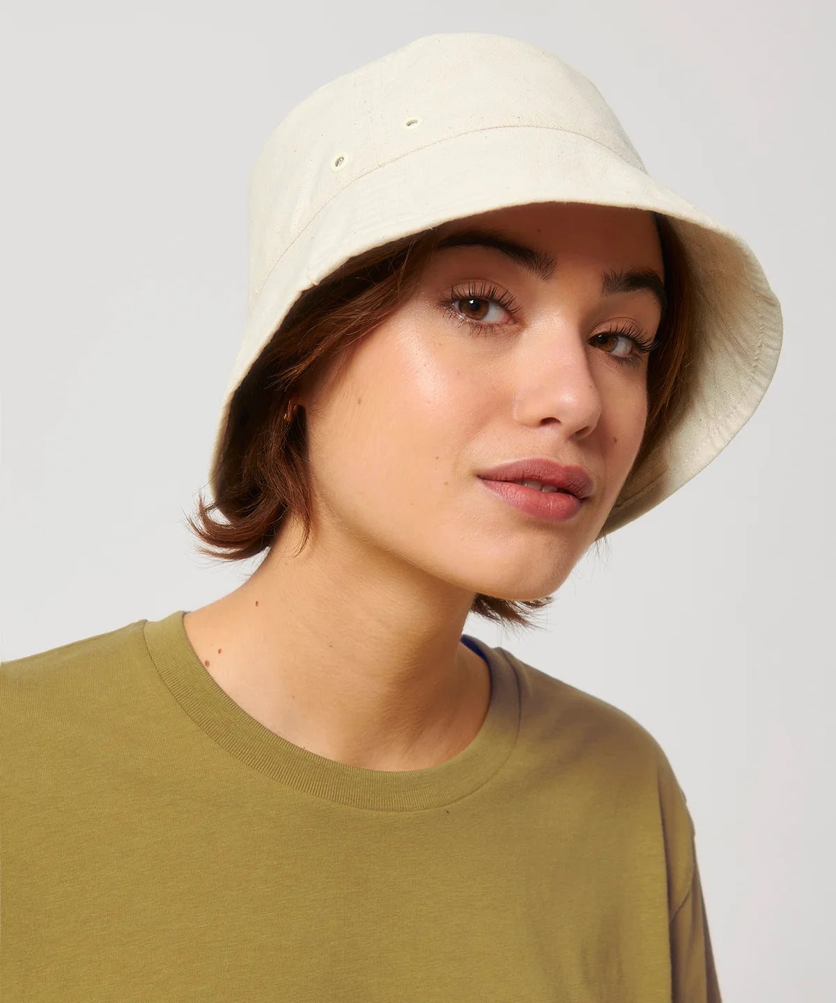 Women wearing natural stanley stella bucket hat with metal eyelets on a white background