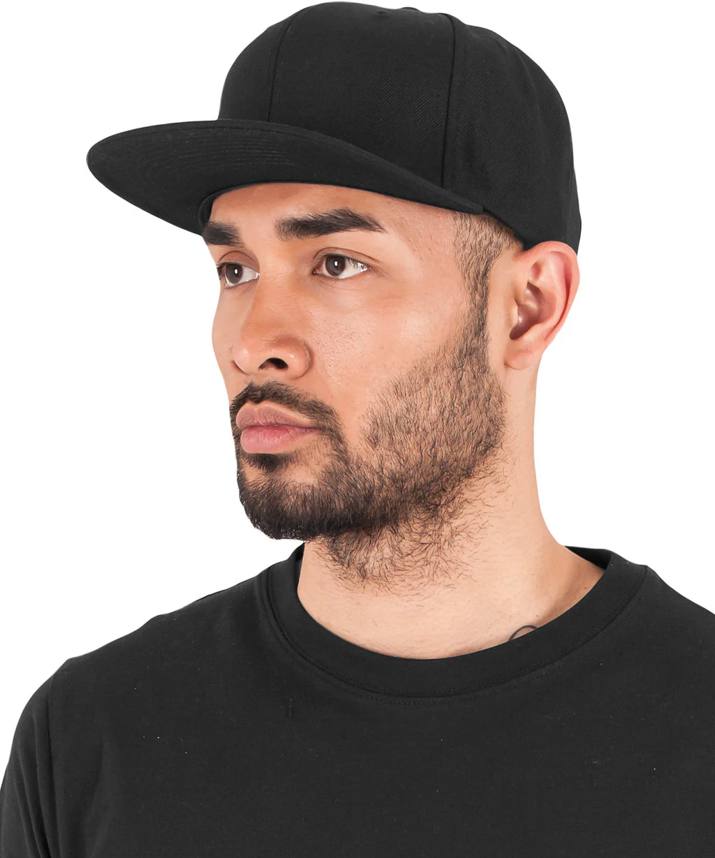model image of male wearing flexfit classic snapback baseball cap in the colour black/black photographed on a white background