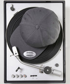 product image of flexfit classic snapback baseball cap in the colour dark grey viewed from above photographed on a record turntable