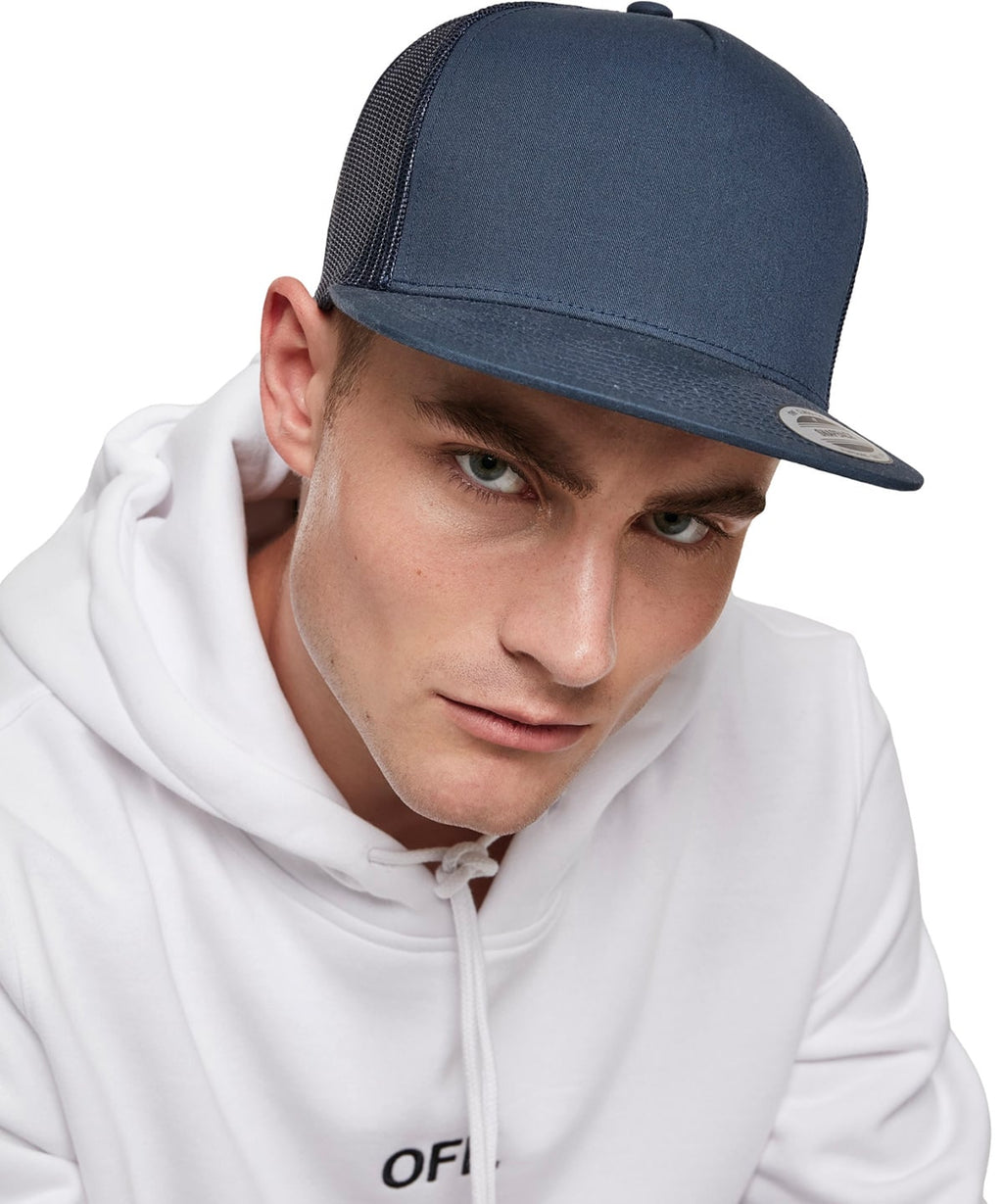 model image of male wearing flexfit classic trucker cap in the colour navy viewed from the front photographed on a white background